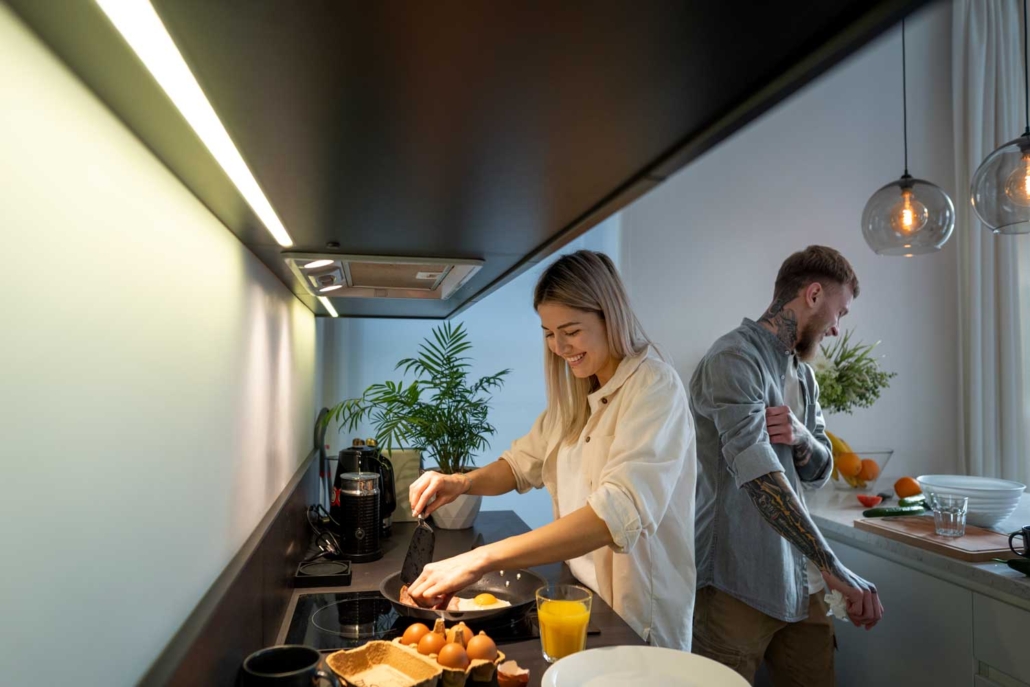 pareja en la cocina haciendo la comida con iluminación funcional