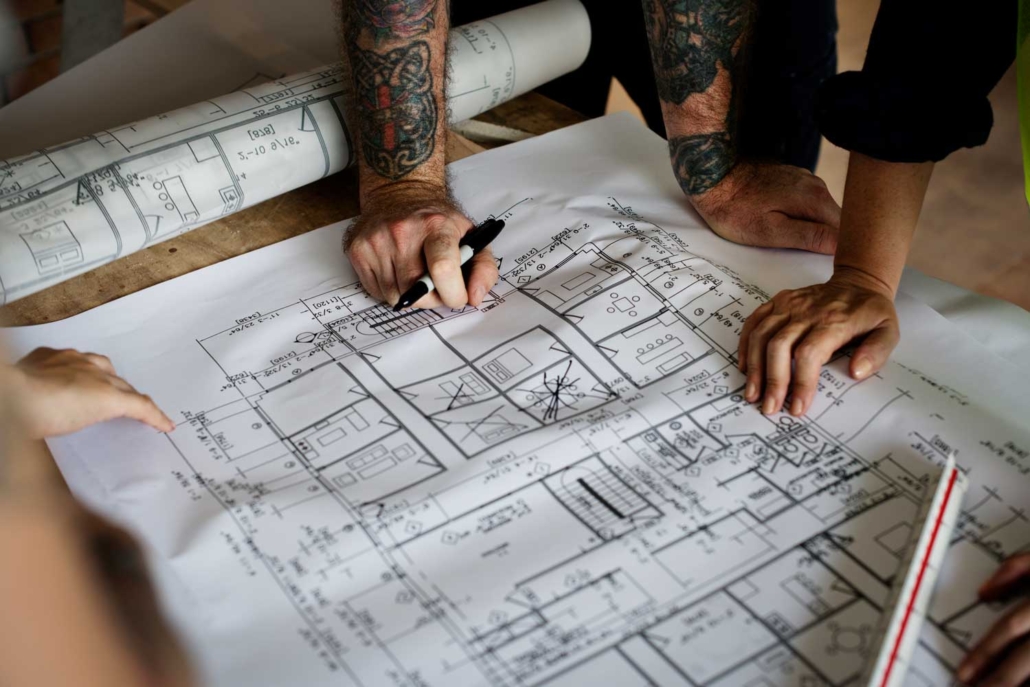 persona con planos de casa para planificar reforma integral de un piso
